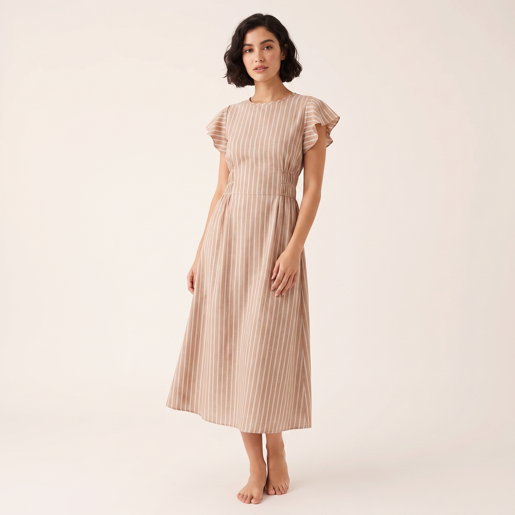 Woman wearing a beige striped dress on a white background
