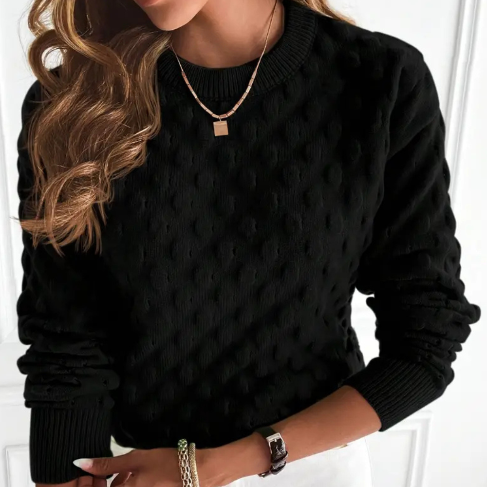 Black long-sleeve crew neck sweater featuring a textured cable knit pattern with ribbed cuffs and hem.