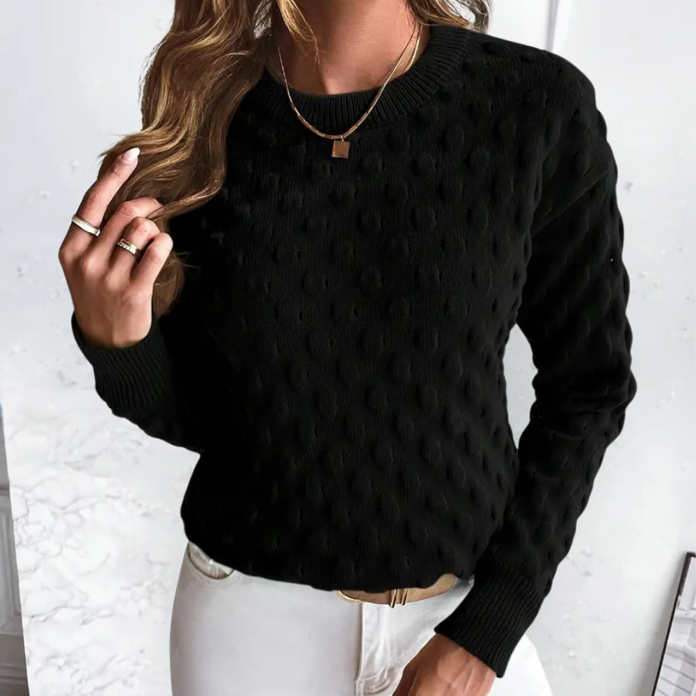 Black long-sleeve crew neck sweater featuring a textured cable knit pattern and ribbed cuffs.