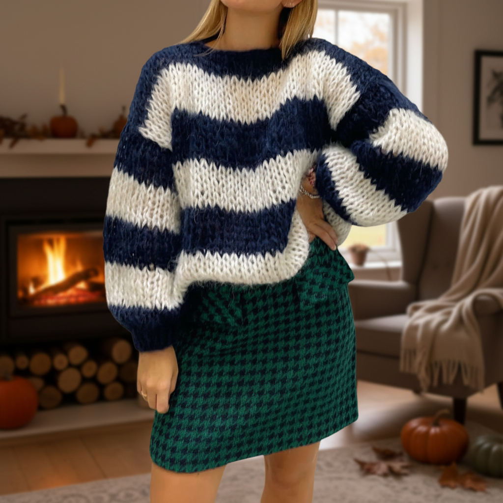 Oversized chunky knit sweater with navy and white stripes, balloon sleeves, and a crew neck, paired with a green skirt.