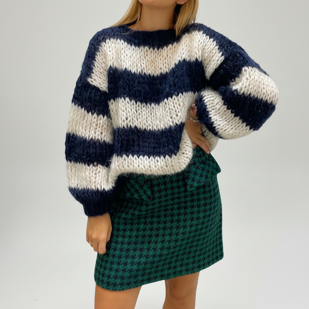 Oversized navy and white striped chunky knit sweater with balloon sleeves and a crew neck, paired with a green houndstooth skirt.