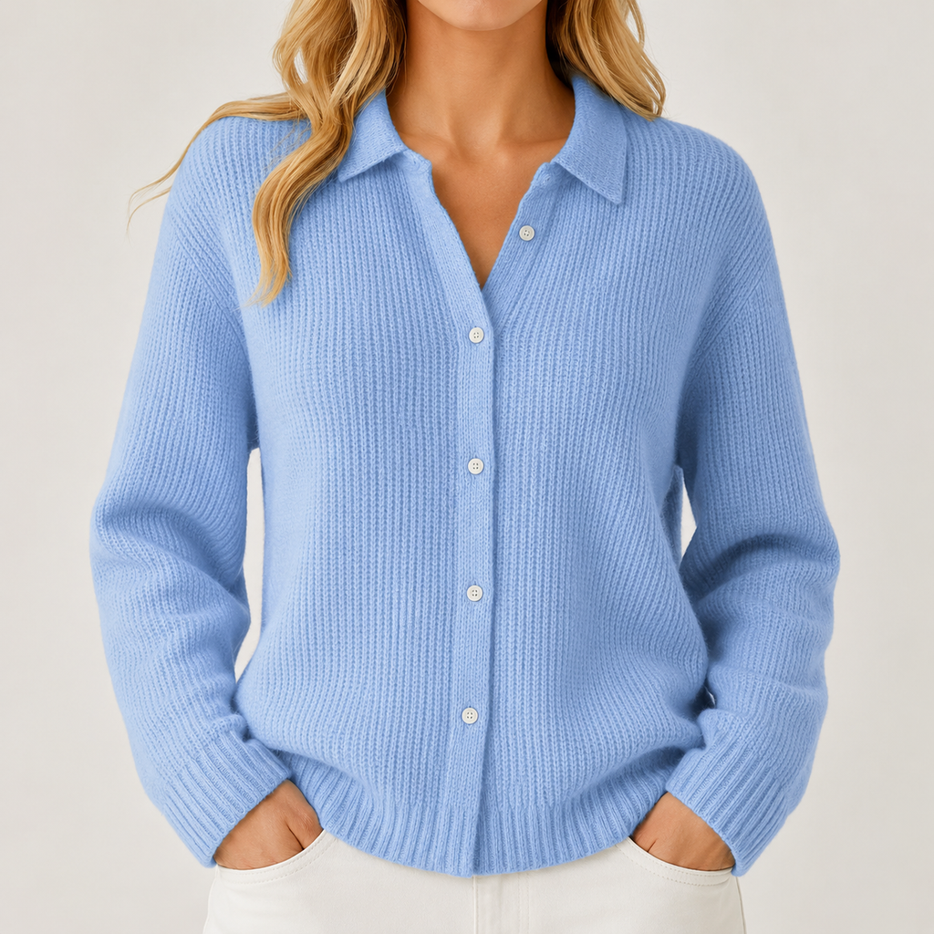 A woman wearing a light blue ribbed knit button-up cardigan sweater with a collar, styled with white pants against a light beige studio background.