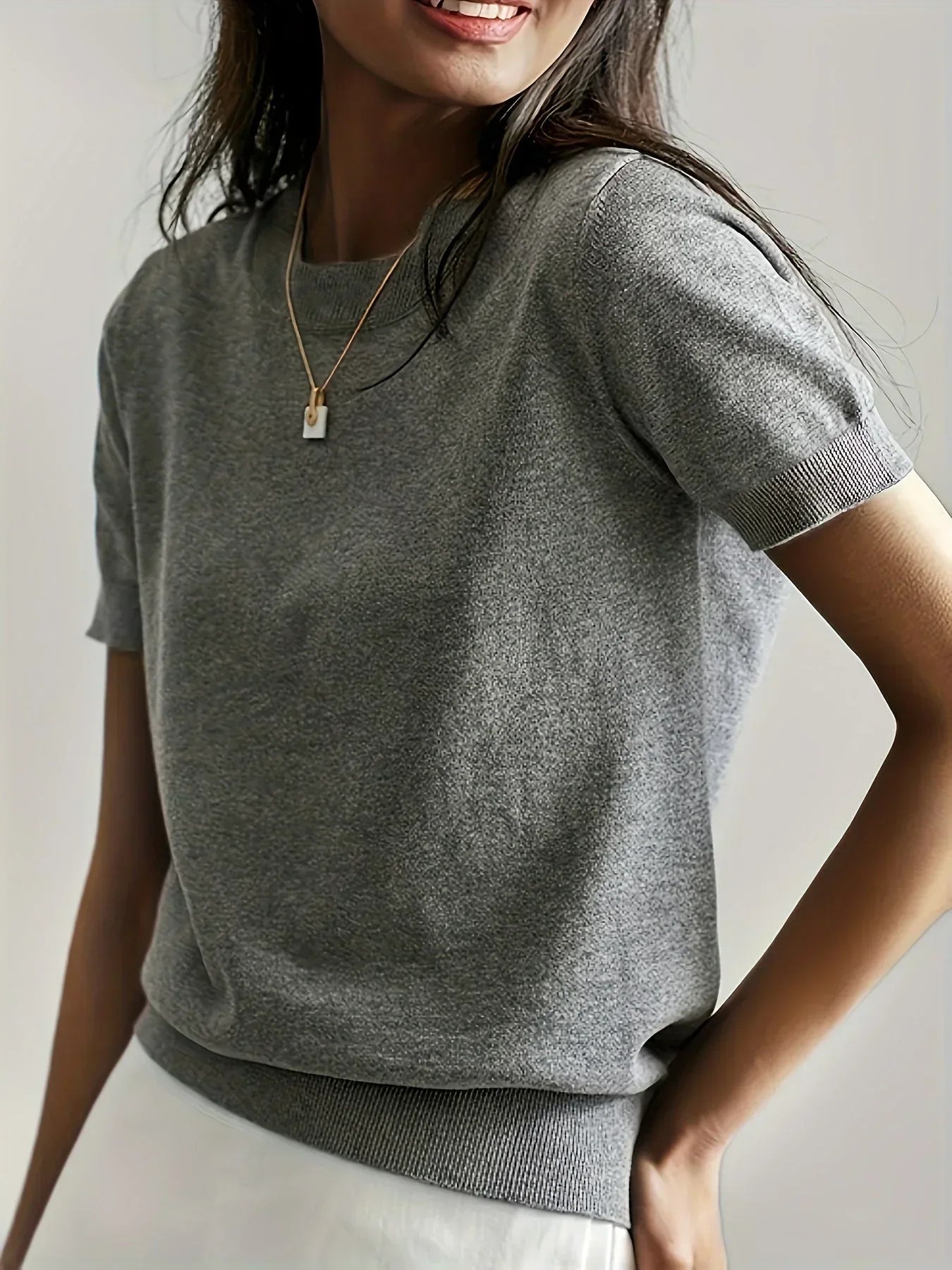 Grey fine knit short sleeve sweater with a crew neck and ribbed trim detail on the sleeves and hem.