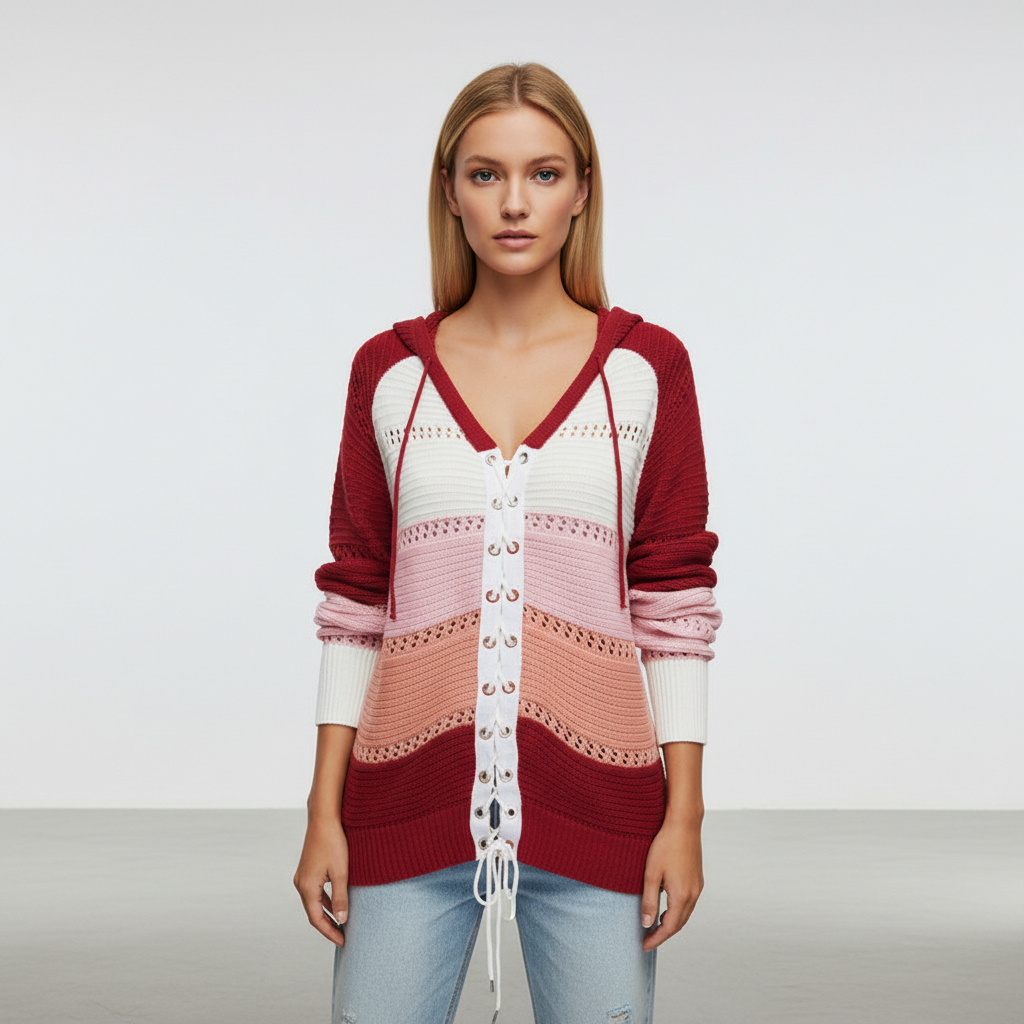 Model wearing a red, pink, and white color-blocked hooded knit sweater with a lace-up front and openwork panels.