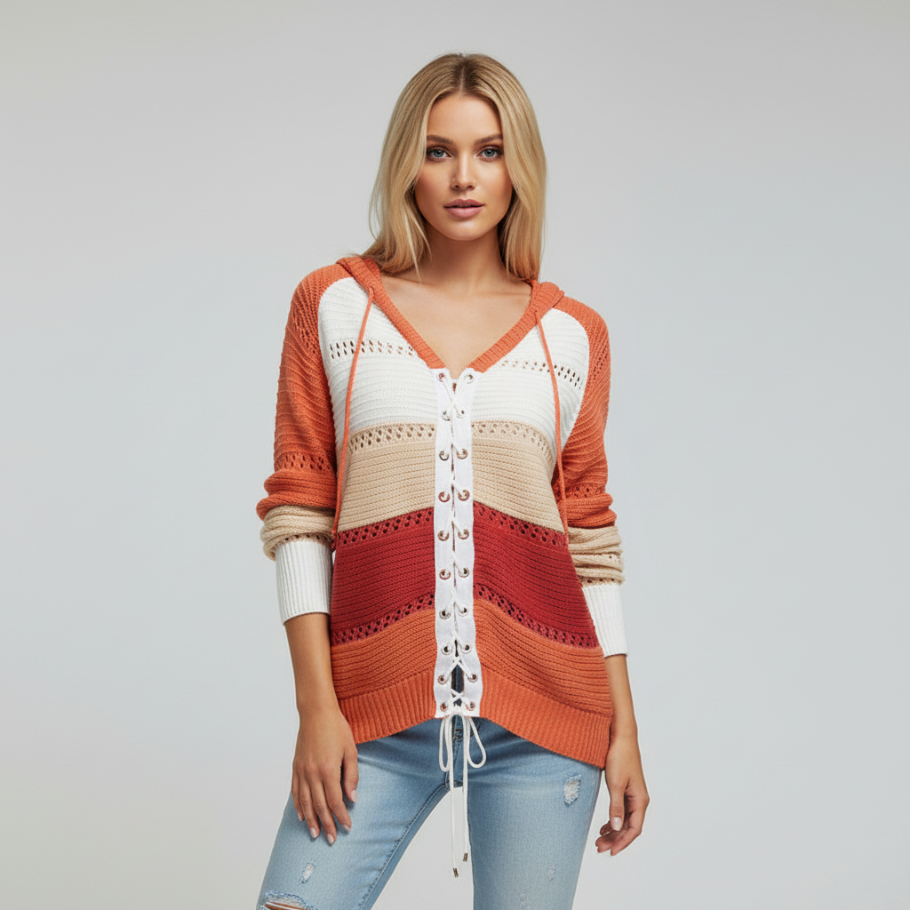 Multi-colored hooded knit sweater with openwork panels and a white lace-up front detail worn with light wash jeans.