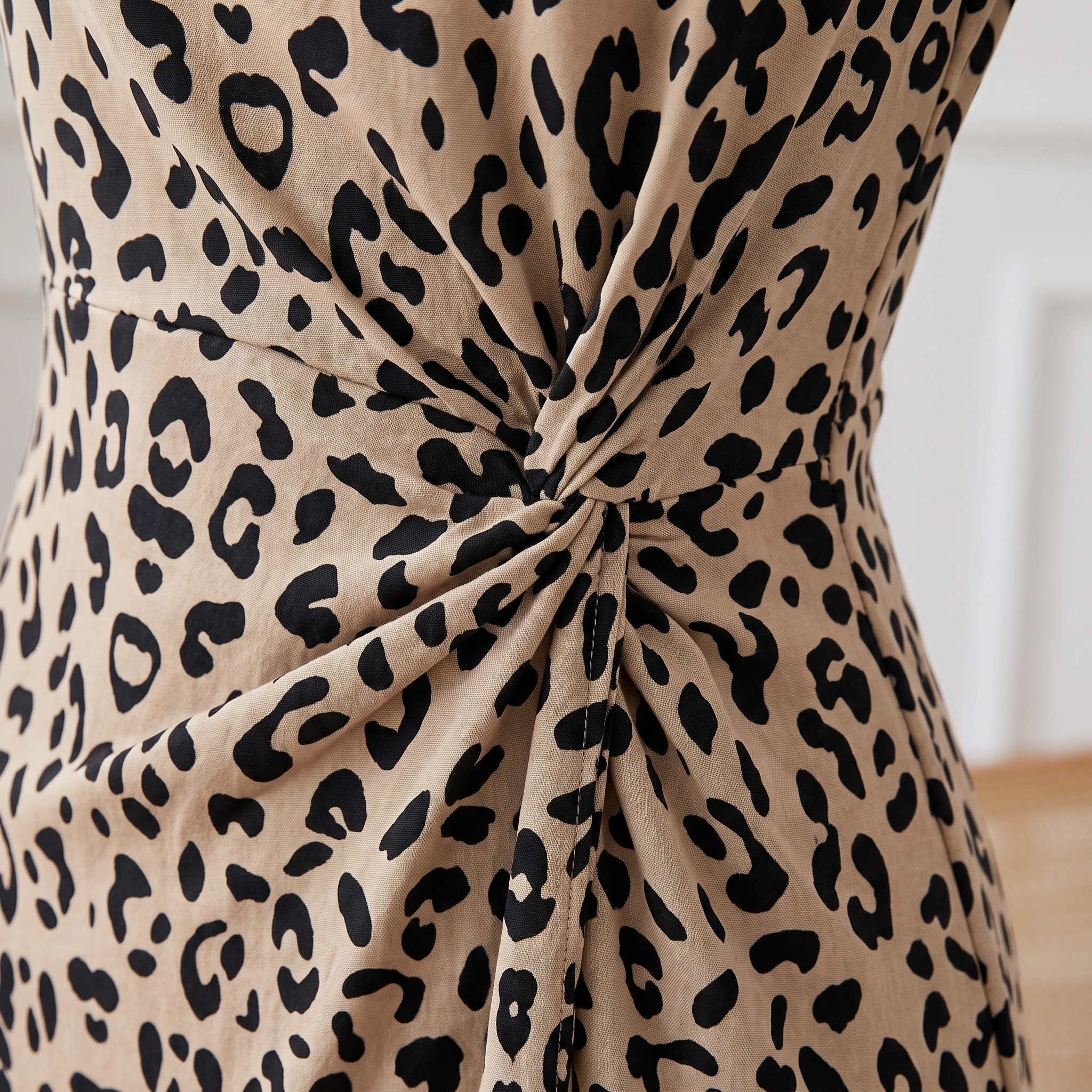 Leopard print dress with a knot detail on a neutral background