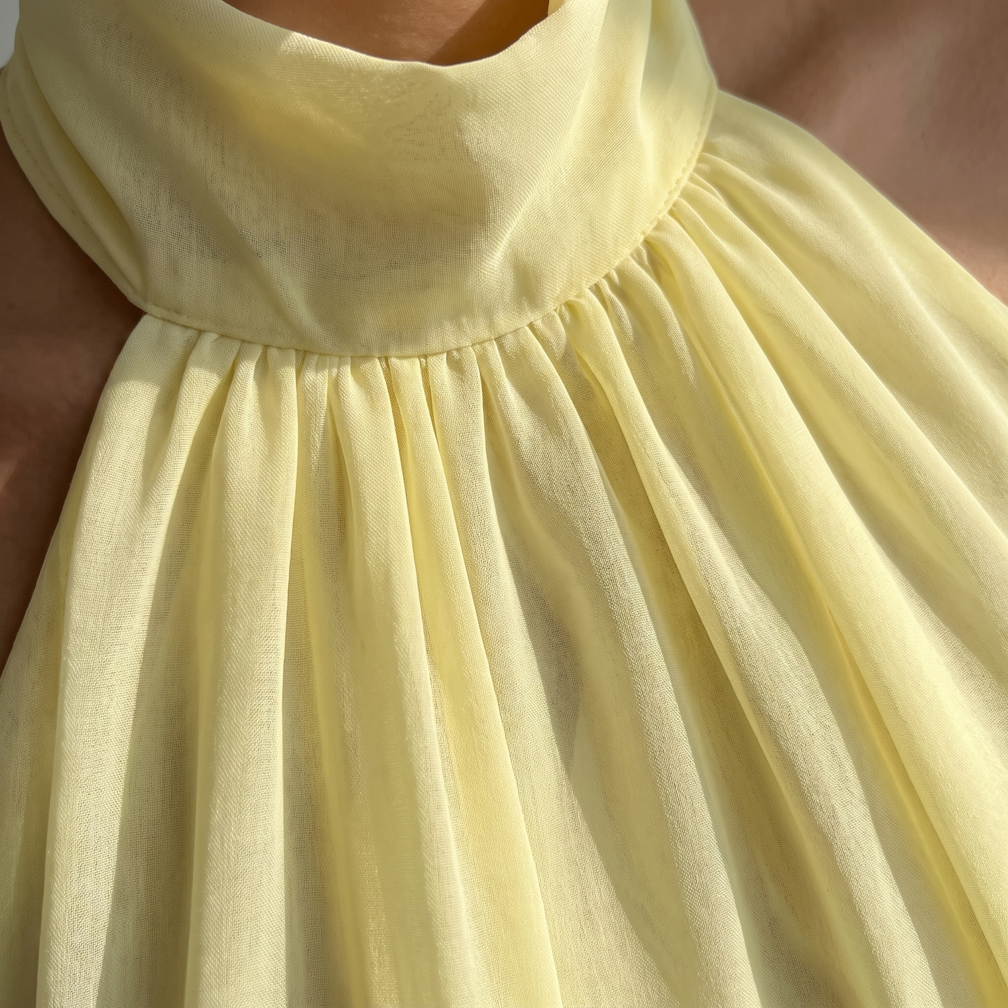 Close-up of a yellow dress with a focus on the fabric texture.