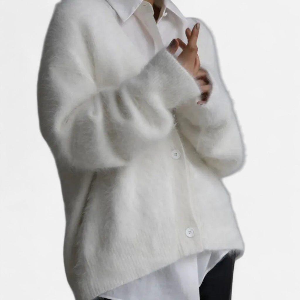 White loose-fit V-neck cardigan in soft, fuzzy knit with a button-up front layered over a crisp white shirt.