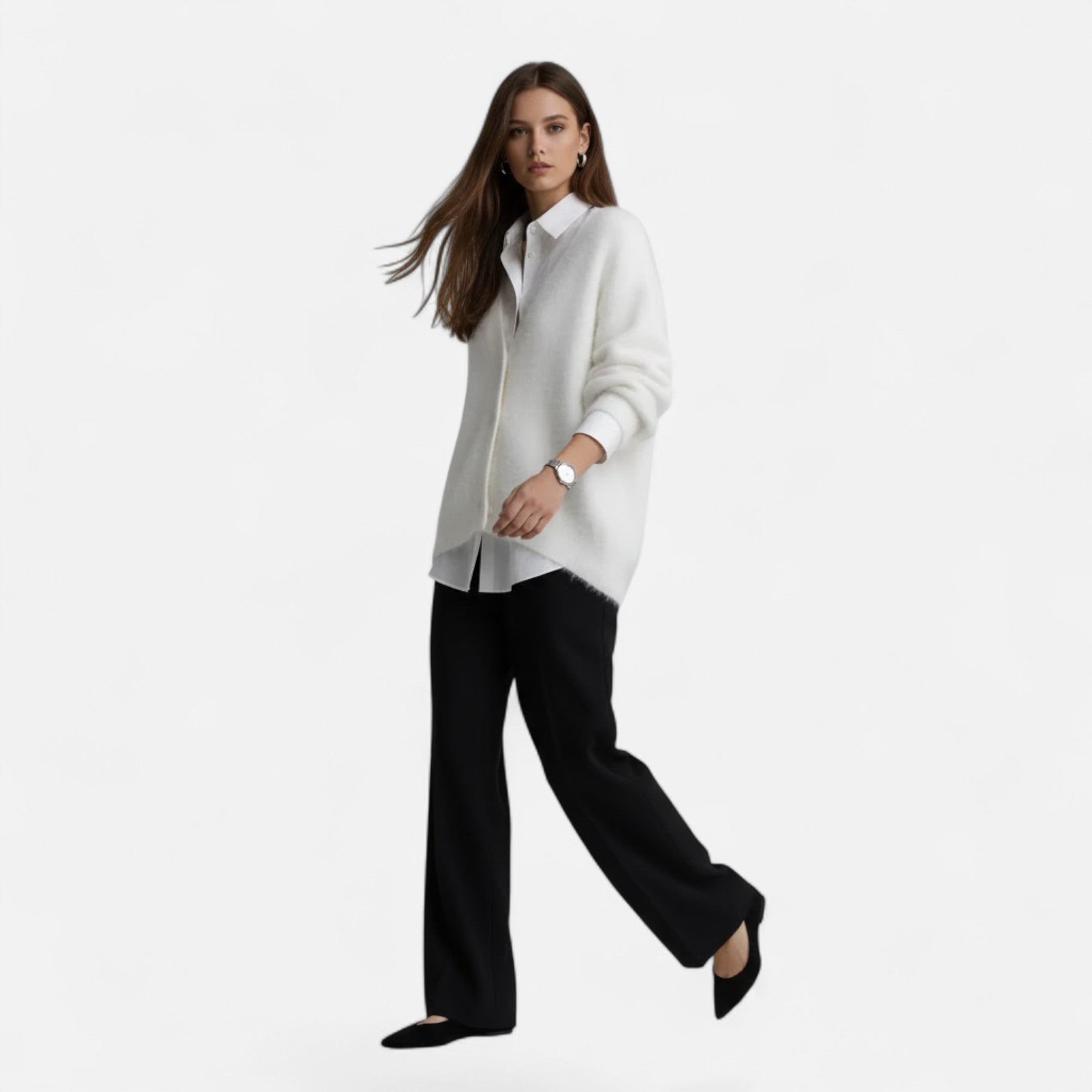 Woman wearing a soft white V-neck buttoned knit cardigan over a crisp white shirt and black trousers.