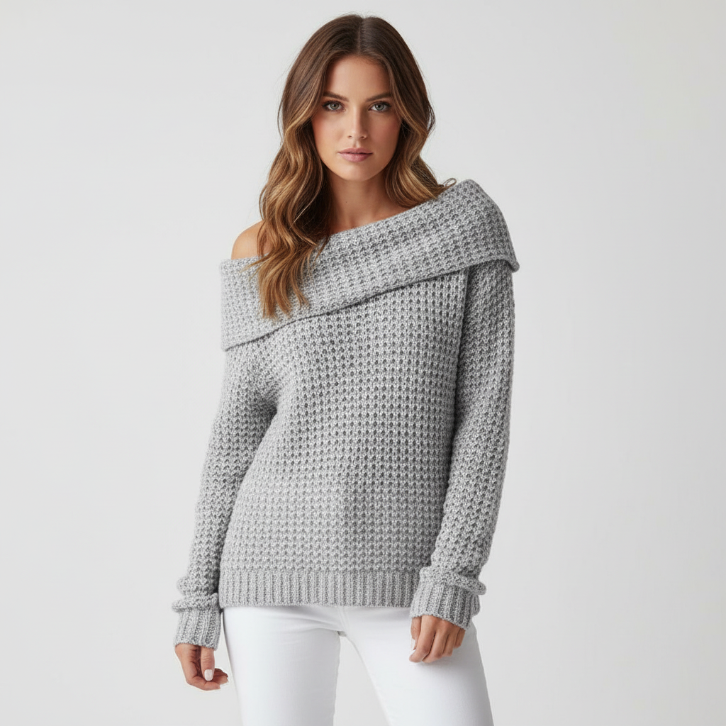 Gray off-shoulder sweater with a textured open knit, long sleeves, and a folded neckline worn with white trousers.