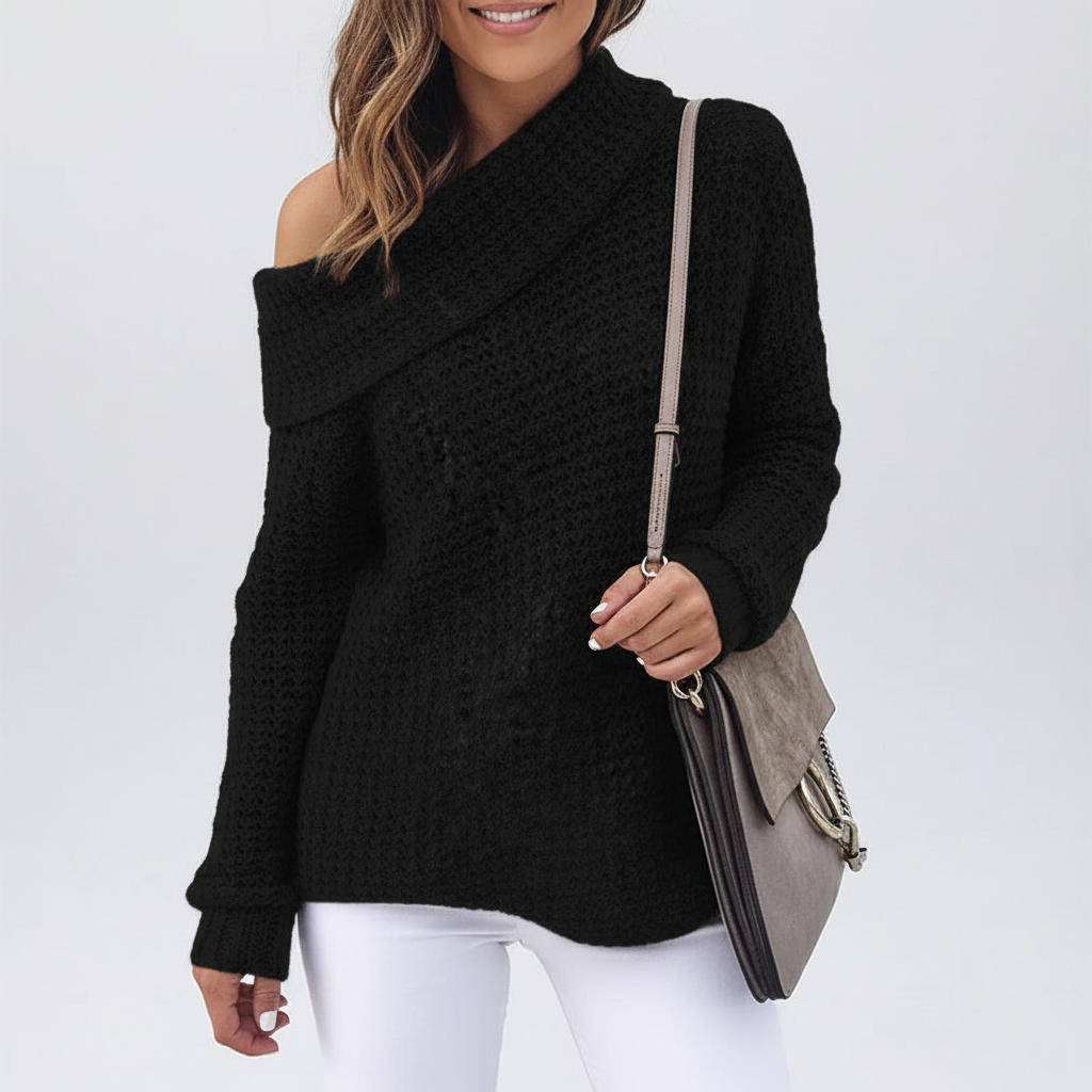 Black off-shoulder sweater with a textured open knit, folded neckline, and long sleeves worn with white trousers.