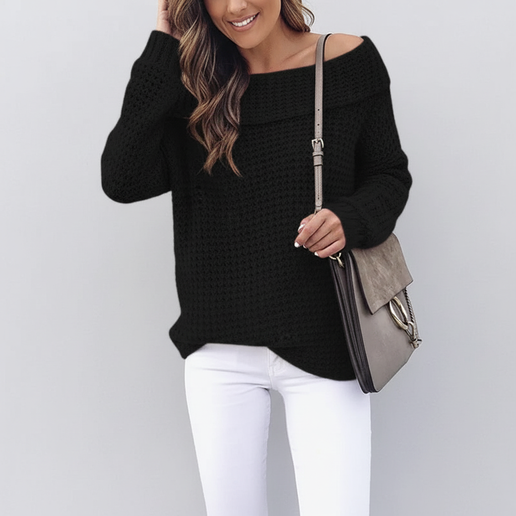 Black off-shoulder sweater with an open knit texture, long sleeves, and a folded neckline worn with white jeans.