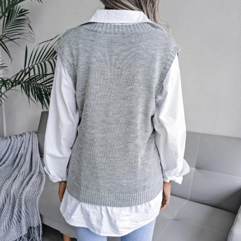 Grey openwork ribbed sweater vest layered over a white button-down shirt, featuring a relaxed fit and extended shoulders.