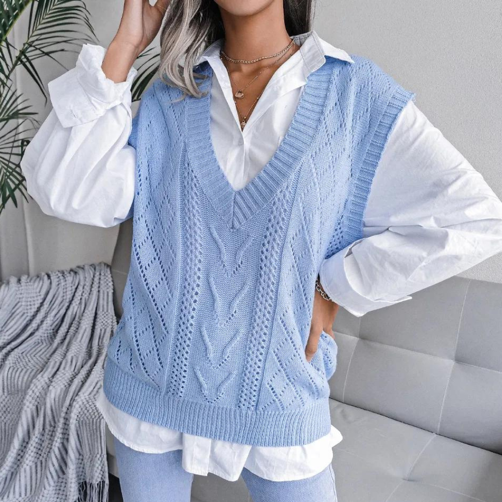 Light blue openwork ribbed V-neck sweater vest layered over a white button-down shirt.