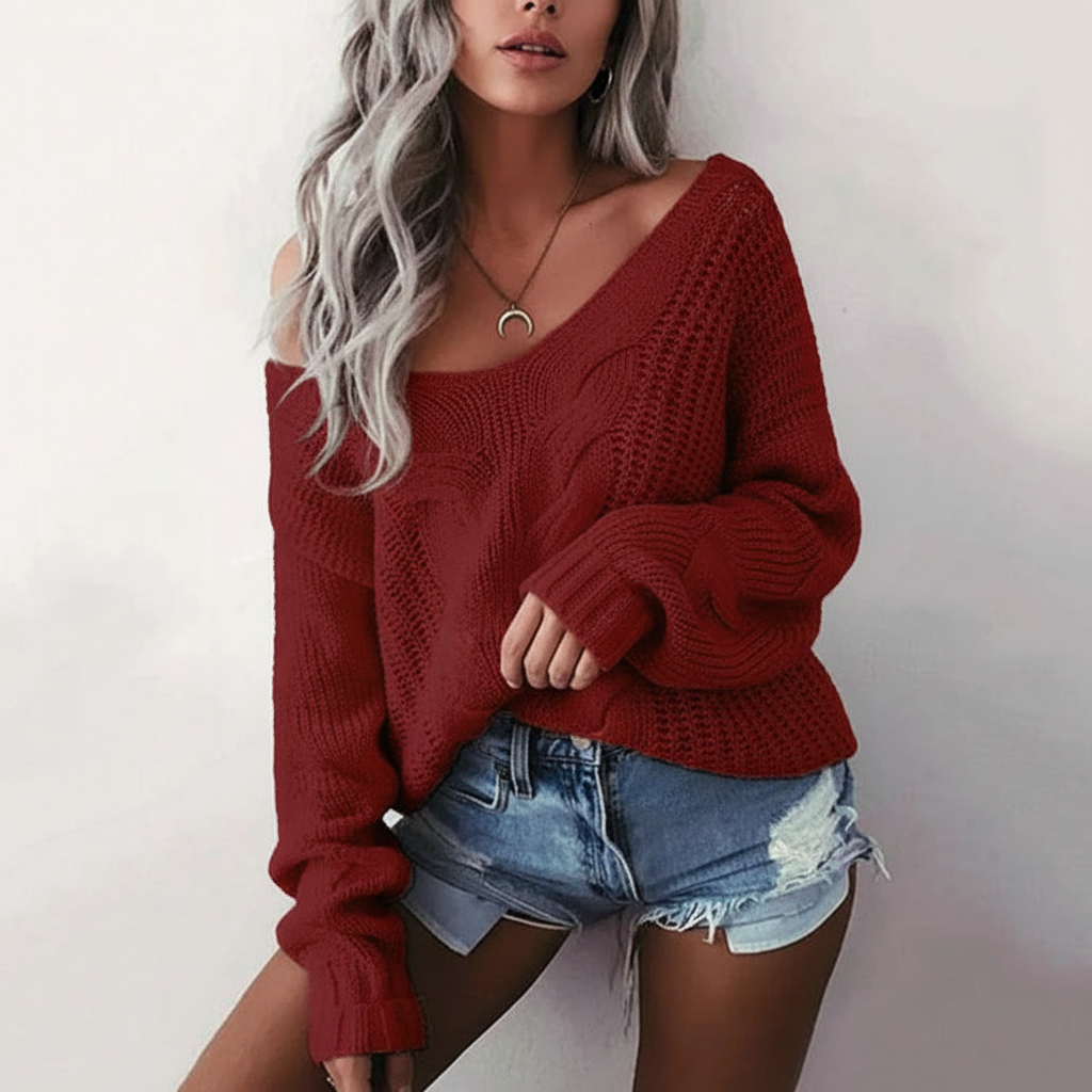 Wine red oversized cable knit sweater with a wide neckline and long sleeves, styled with distressed denim shorts.