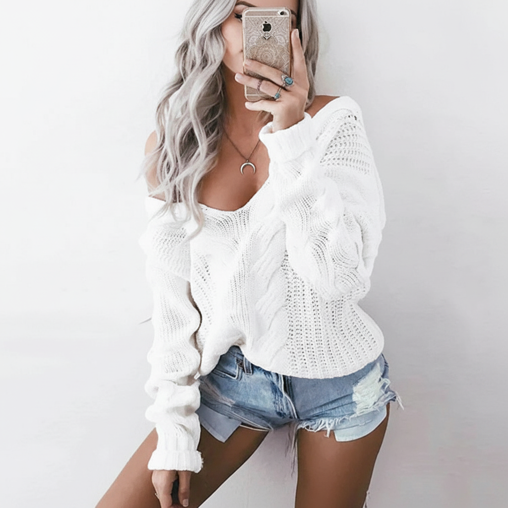 Oversized white cable knit sweater with a wide neckline, openwork details, and long sleeves with ribbed cuffs.