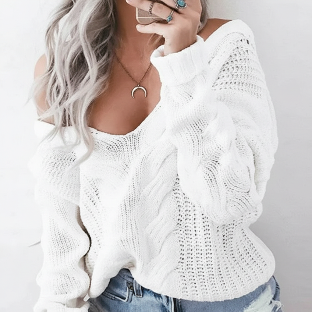 Oversized white cable-knit sweater with an openwork design, wide neckline, and long sleeves with ribbed cuffs.
