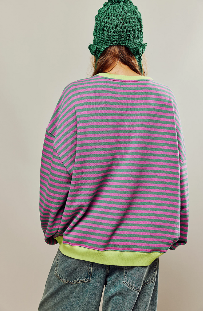 Oversized pink and green striped sweatshirt with balloon sleeves and lime green ribbed trim worn with denim jeans.