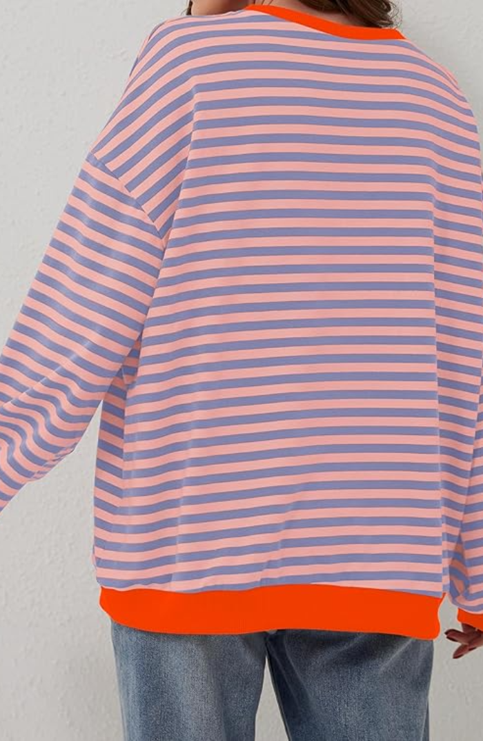 Oversized striped sweatshirt in pink and blue with a bright orange ribbed hem and balloon sleeves.