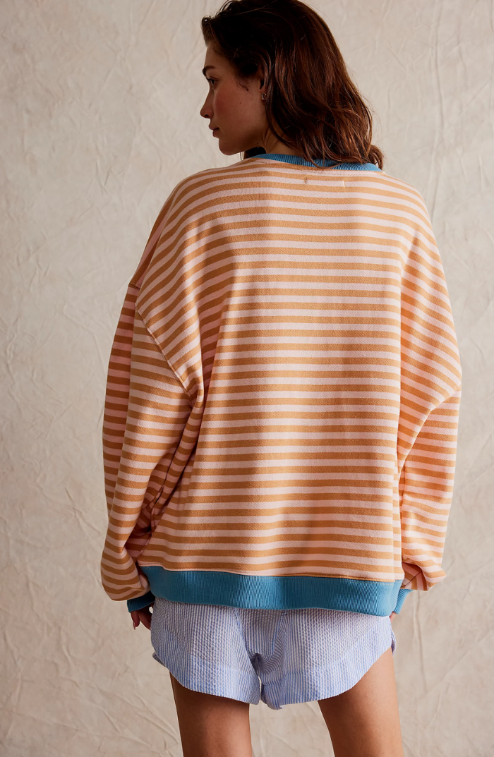 Oversized striped sweatshirt in peach and cream with blue ribbed trim and relaxed balloon sleeves.
