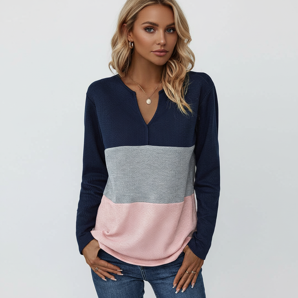 Relaxed fit sweater featuring a split V-neck, long sleeves, and horizontal panels in navy, grey, and soft pink ribbed knit.