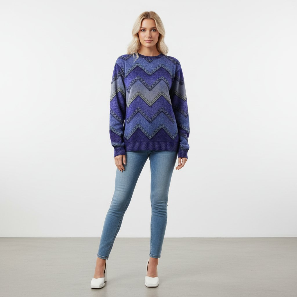 Relaxed blue crew neck knit sweater with a chevron print, long sleeves, and ribbed cuffs worn with blue jeans.