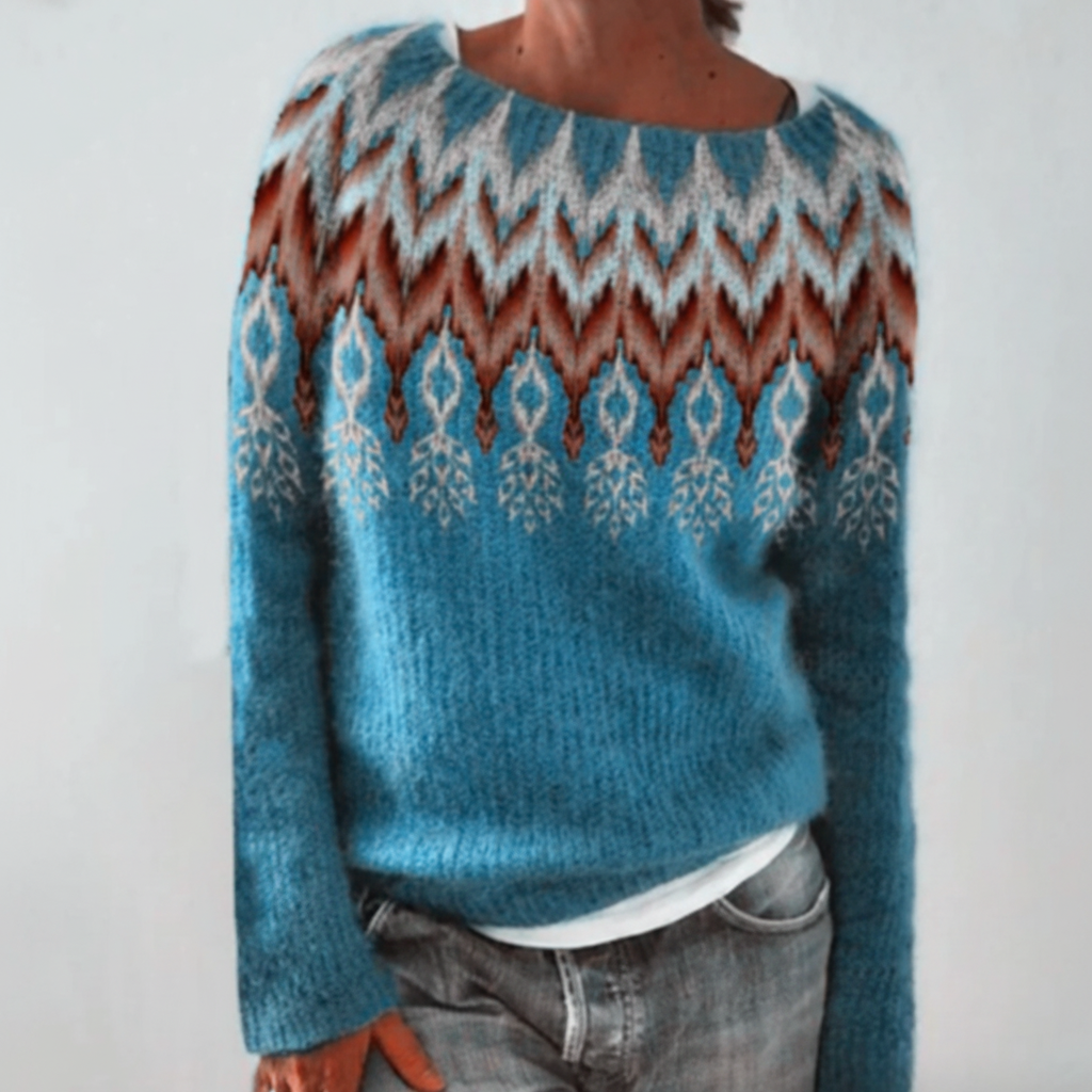 Blue green long-sleeve sweater featuring a round neckline, ribbed cuffs, and a decorative brown and white geometric print.