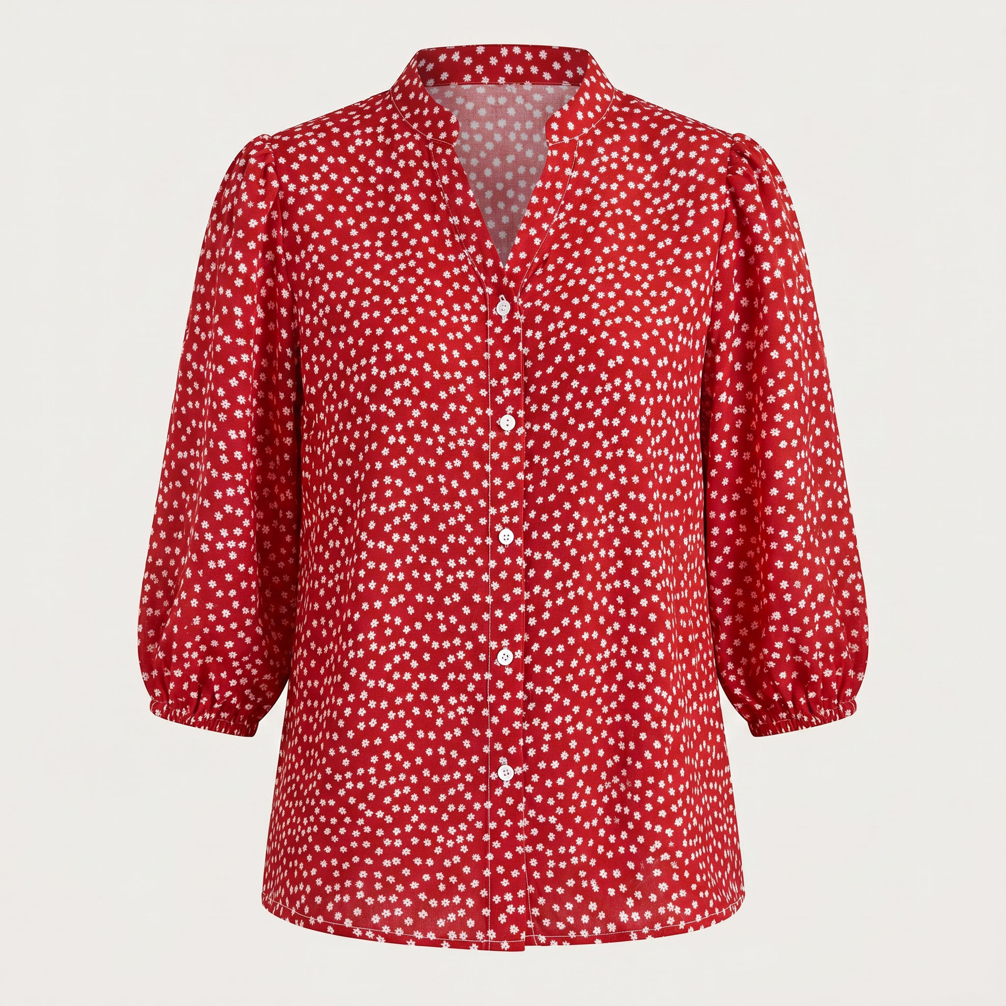 A red long-sleeve blouse with a white polka dot pattern, featuring a split V-neckline and decorative buttons down the front, displayed on a neutral light gray background.