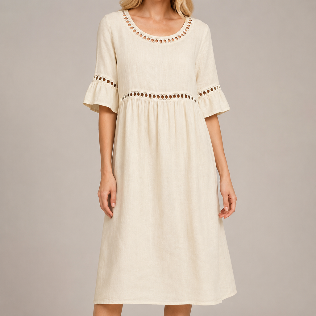 White female model wearing a relaxed cream linen-look midi dress with eyelet trim, flared sleeves and a gathered waist in a neutral studio setting.