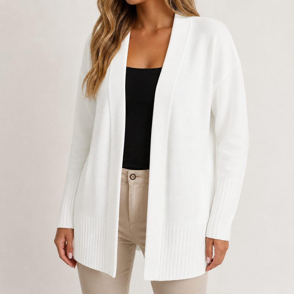 A woman wearing a white open-front knit cardigan over a black top and beige pants, photographed against a plain light background.