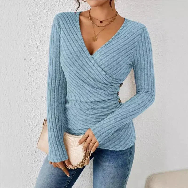 Light blue ribbed knit wrap top with a V-neck, long sleeves, and side button accents for a fitted silhouette.