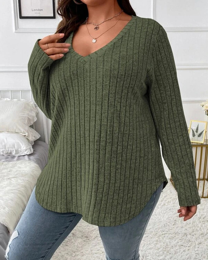 Olive green ribbed V-neck jumper with long sleeves and a relaxed fit, styled with blue jeans.