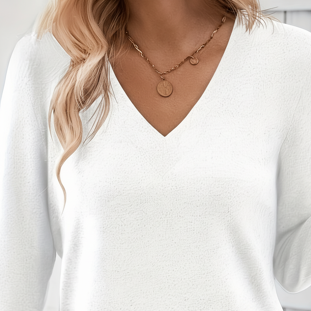 White long-sleeve V-neck sweater with a relaxed fit and soft knit texture.