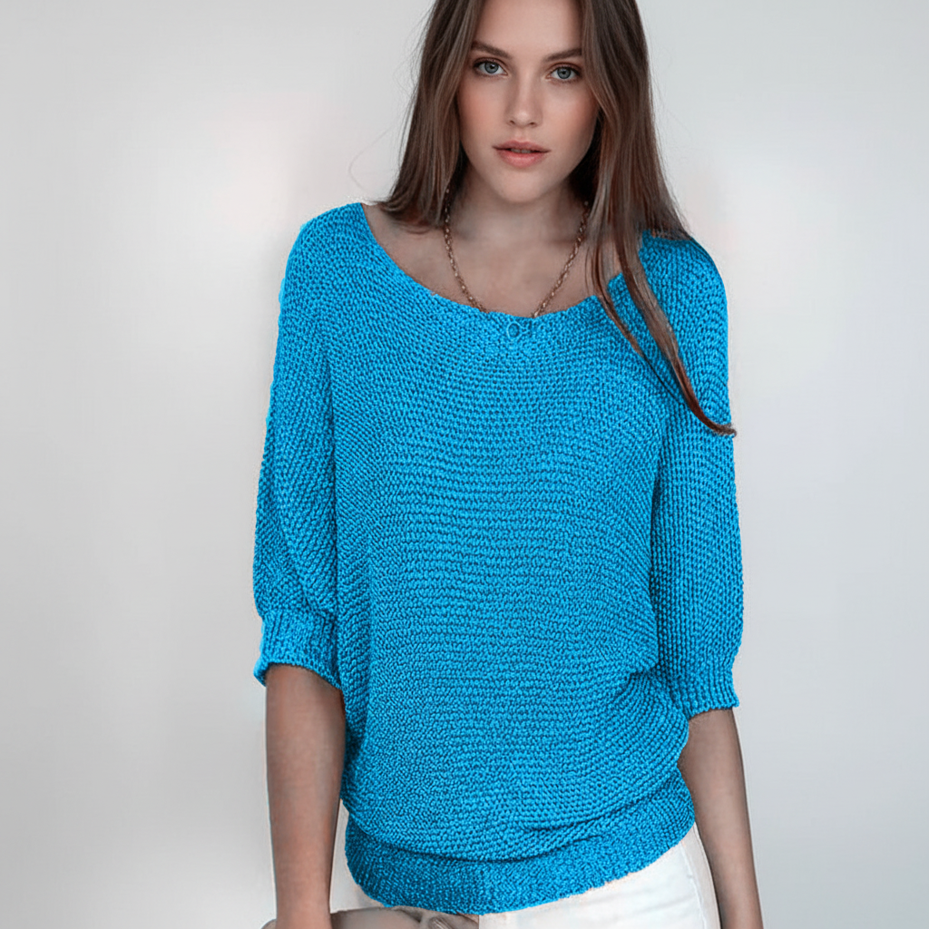 Blue relaxed-fit sweater with a wide neckline, dolman sleeves, and a ribbed hem worn by a woman.