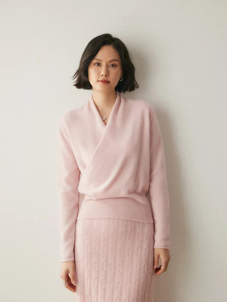 Soft pink slim-fit knit sweater featuring a feminine crossover wrap neckline and long sleeves with ribbed hem.