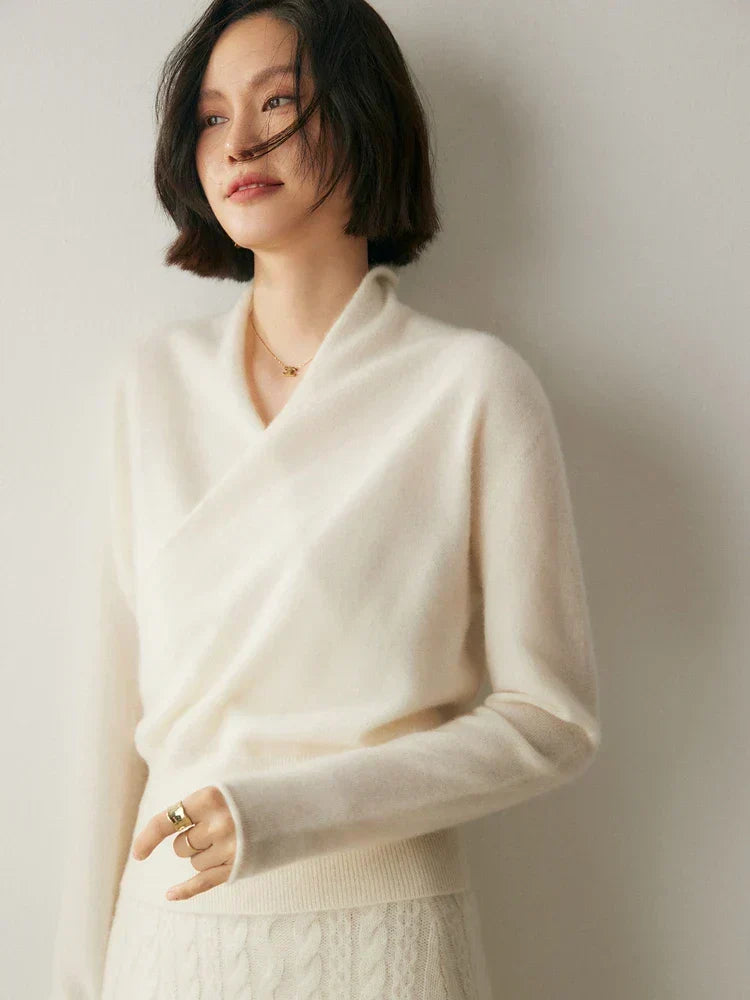 White slim-fit knit sweater featuring a feminine crossover wrap neckline and long sleeves with ribbed cuffs.