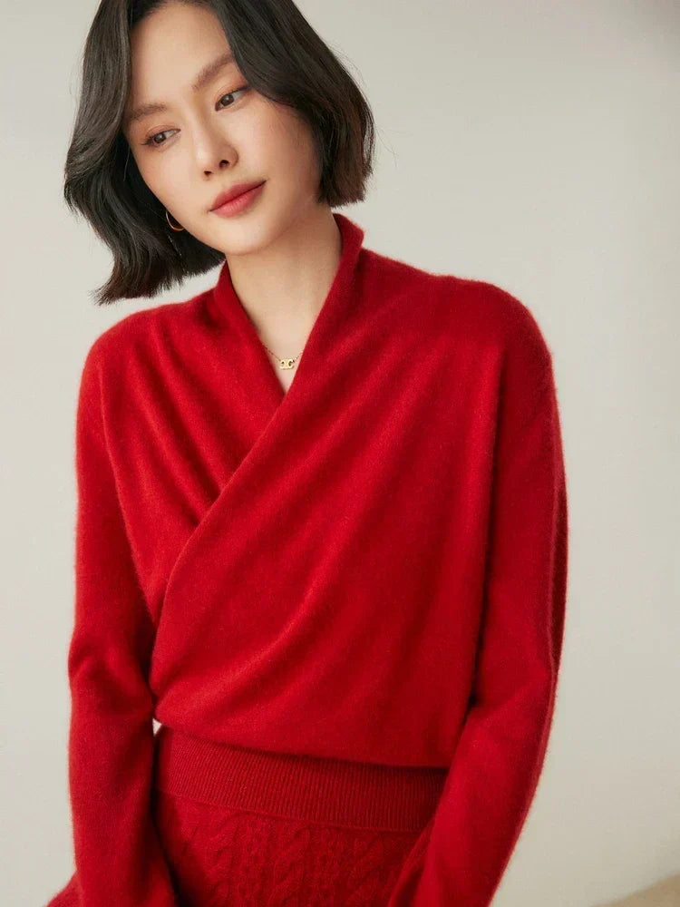 Woman wearing a red slim-fit knit sweater with a crossover wrap neckline and long sleeves.