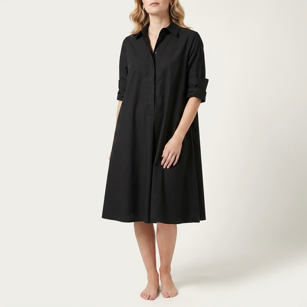 Woman wearing a black collared shirt dress with a waist-height button placket, front studio view
