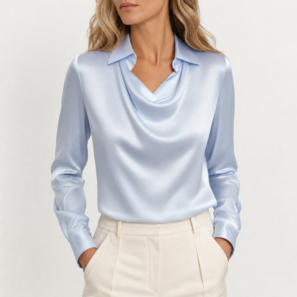 Model wearing blue draped neckline satin blouse with cream trousers