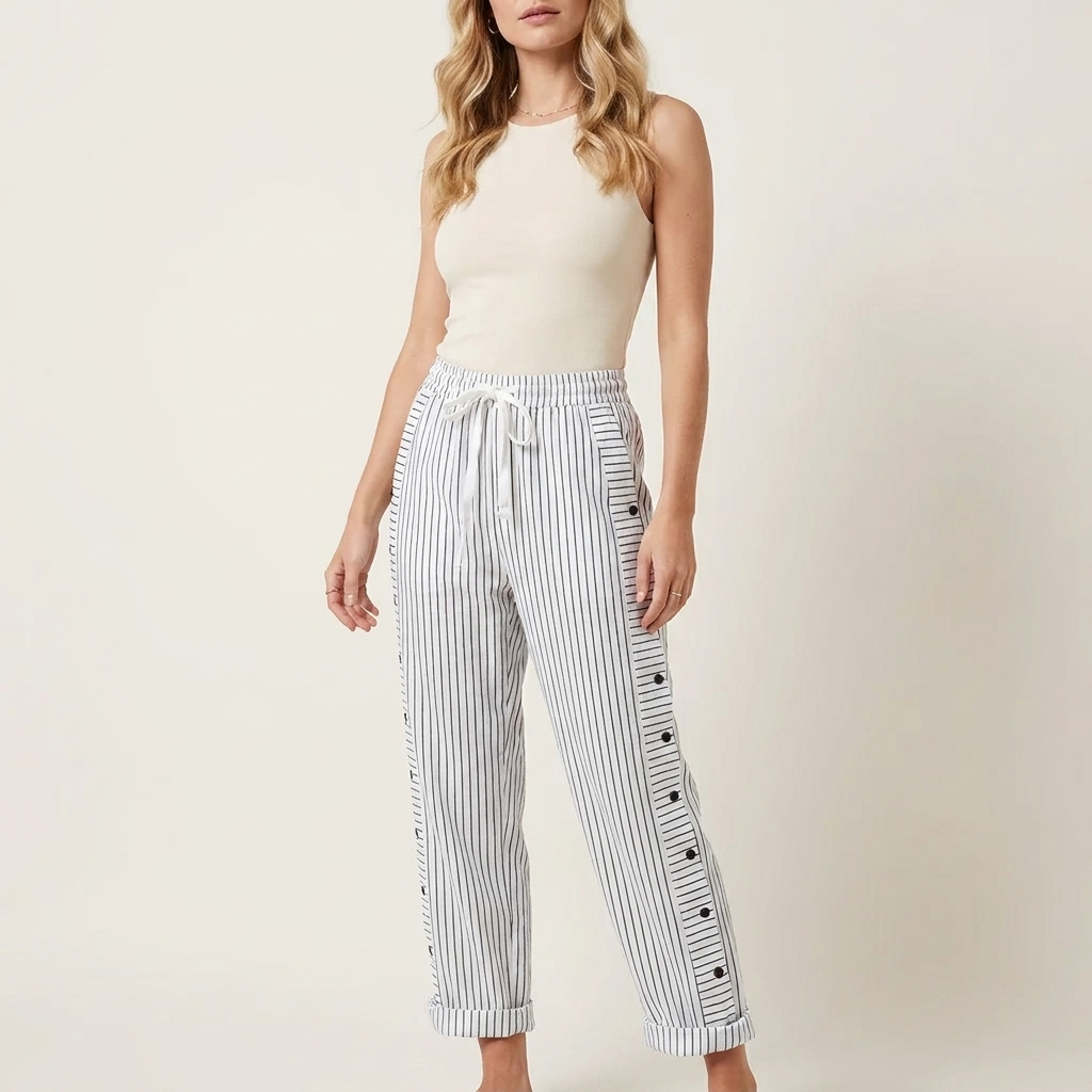Woman wearing gray elasticated drawstring trousers with side button detail and rolled-up hem, front studio view
