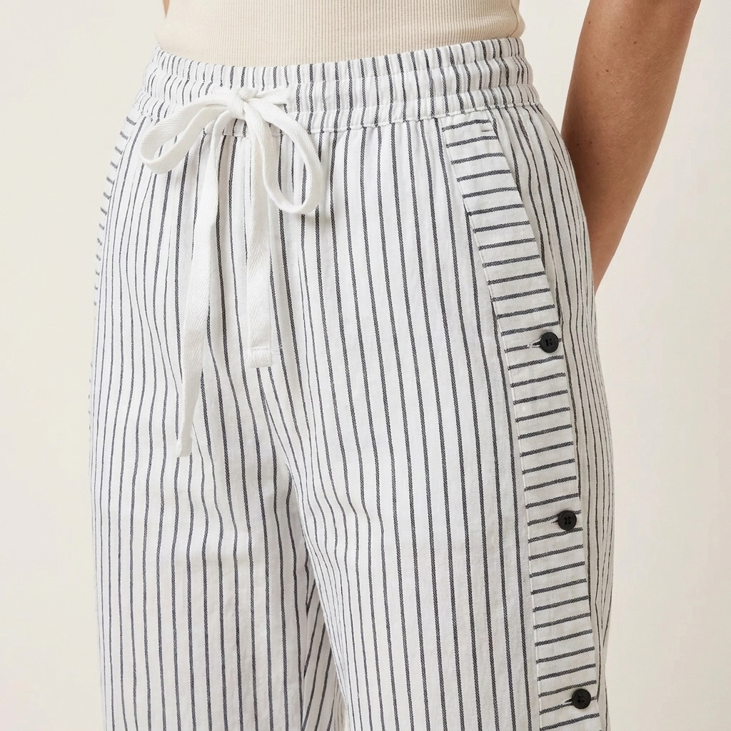 Close-up of the gray trousers waistband, drawstring and side button detail