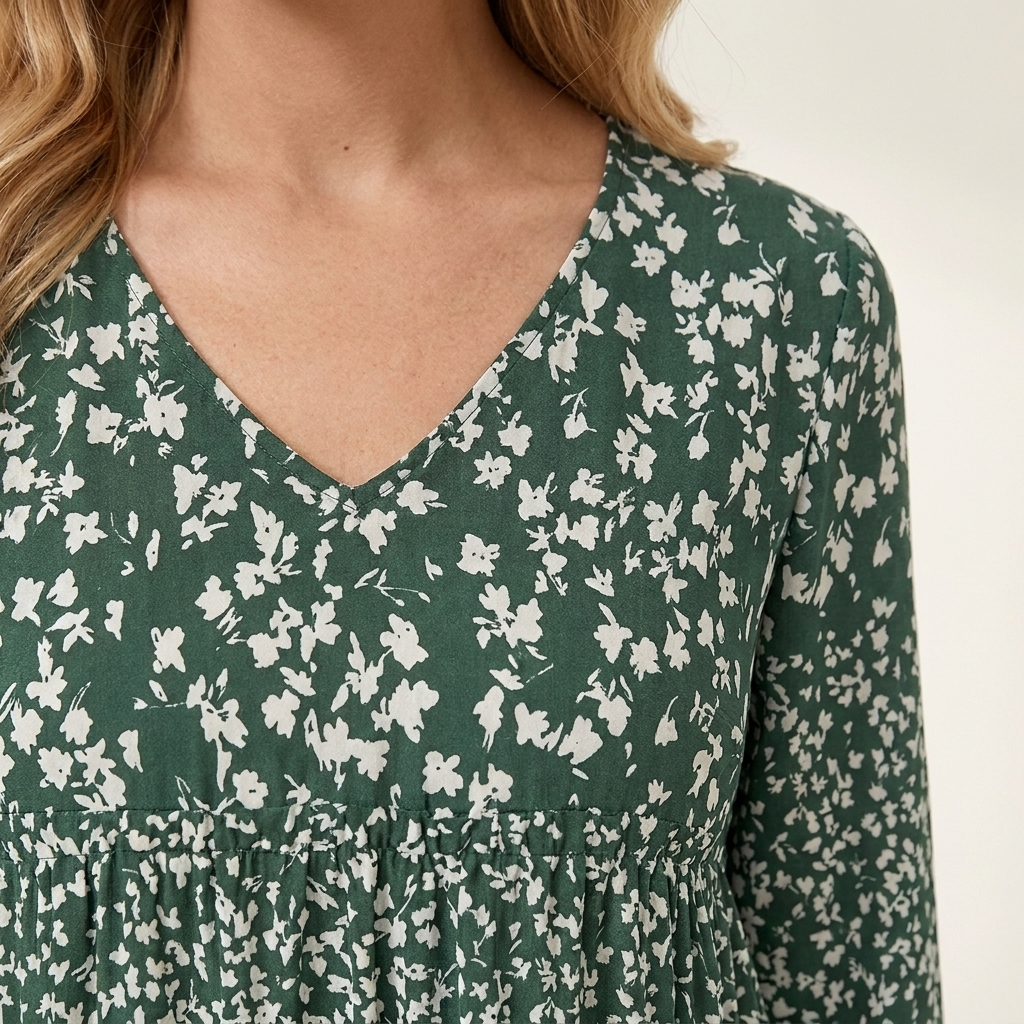 Close-up of the green dress neckline and fabric texture showing seam detail