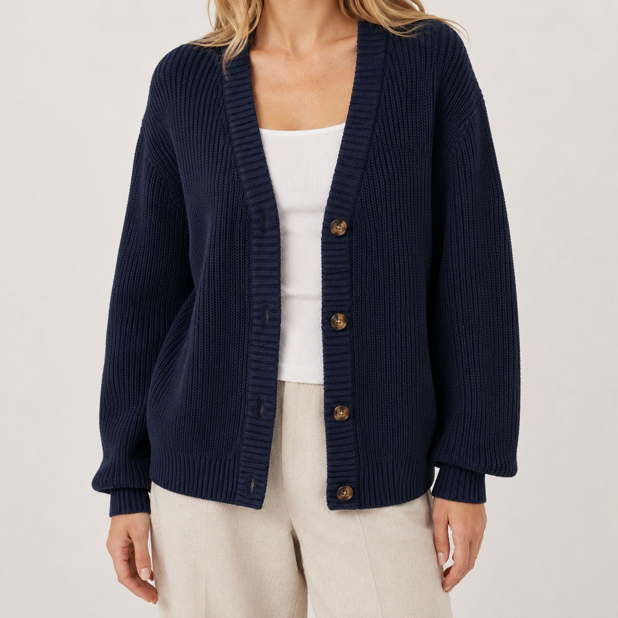 Navy blue ribbed knit cardigan with a deep V-neck, button-front closure, and relaxed dropped-shoulder fit.