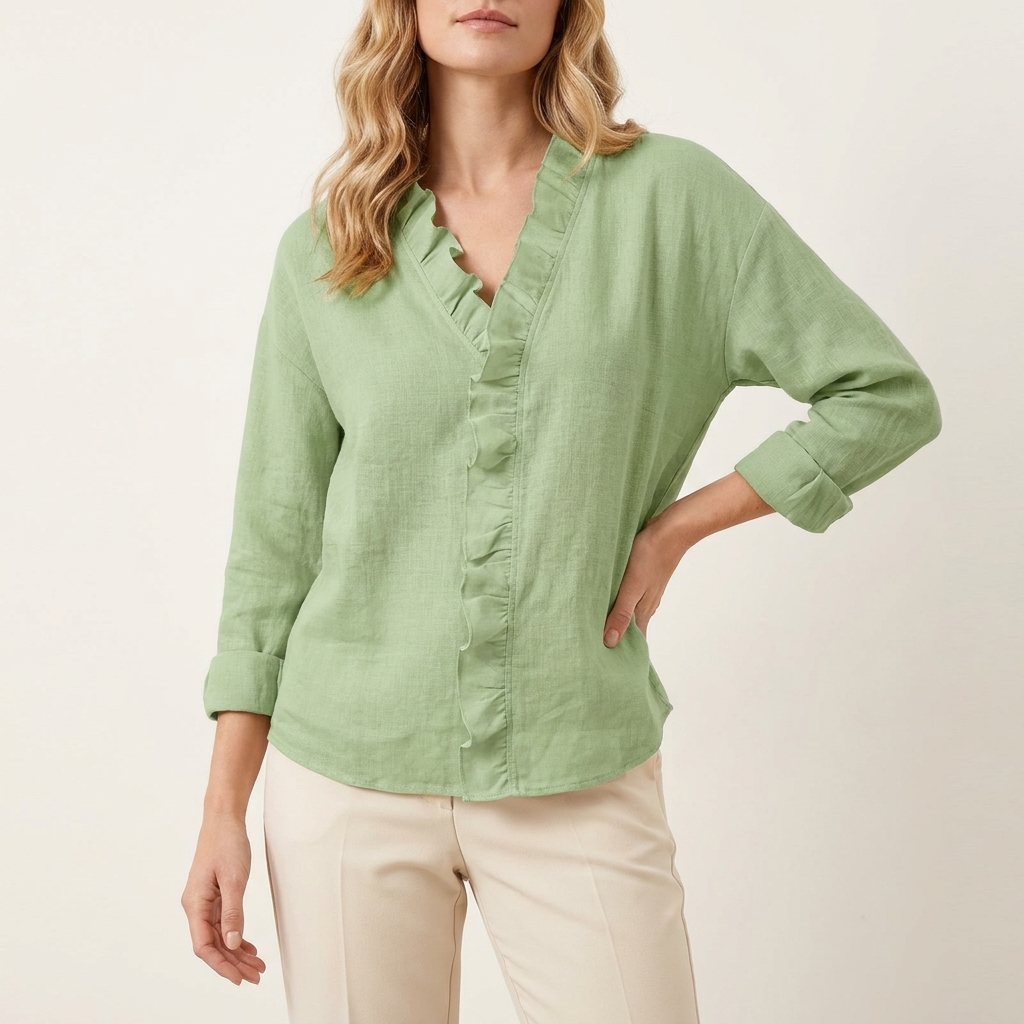 Woman wearing a green ruffled V-neck blouse with long sleeves, front studio view